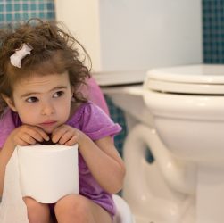 маленька дівчинка сидить на горщику у ванній кімнаті