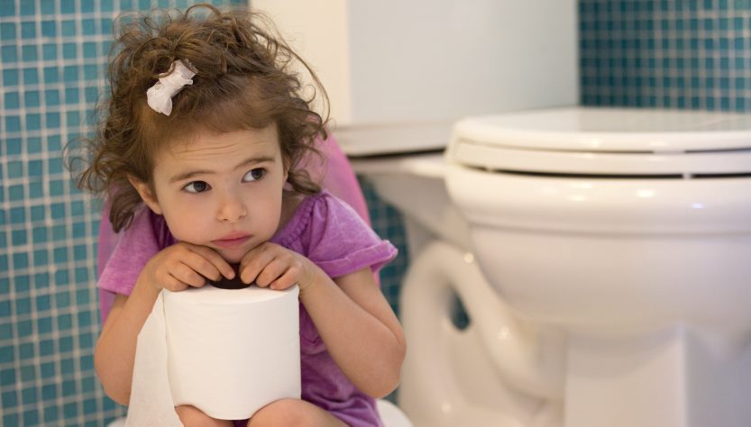 маленька дівчинка сидить на горщику у ванній кімнаті