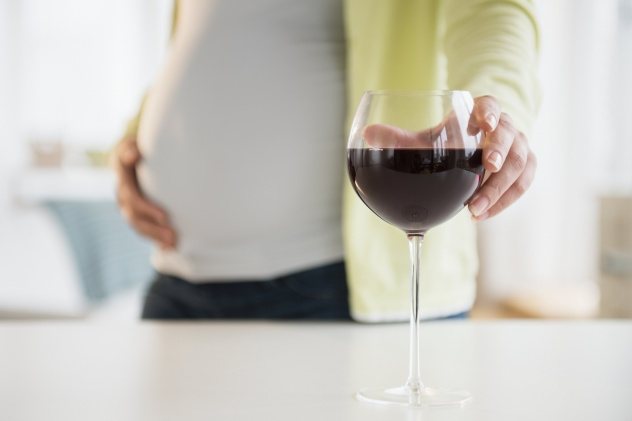 вагітна бере келих з вином