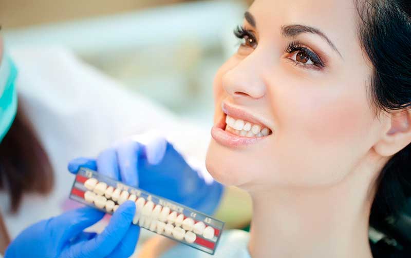 Процесс подбора цвета коронки (после проведения имплантации переднего зуба)