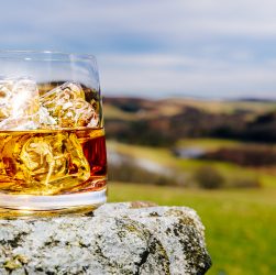 Стакан виски со льдом на открытом воздухе Шотландия