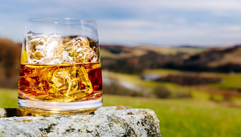 Стакан виски со льдом на открытом воздухе Шотландия
