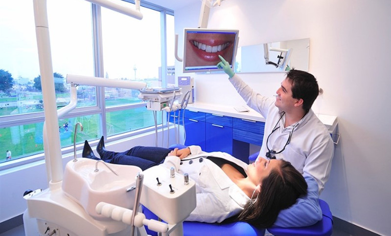 Стоматолог показывает состояние зубов пациенту
