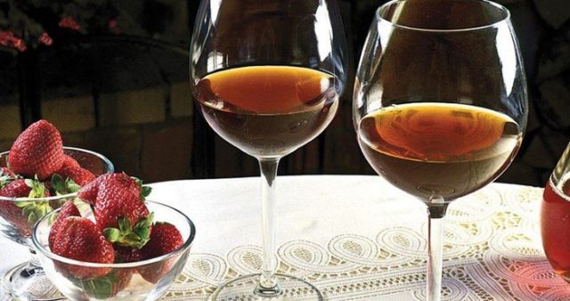 вино в келихах і ягоди полуниці на столі